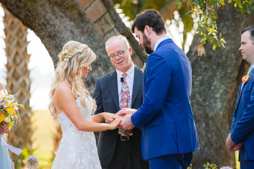 Lowndes Grove wedding groom placing wedding ring on bride's finger