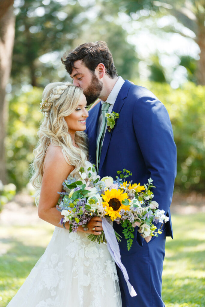 Lowndes Grove wedding groom kissing bride's forehead