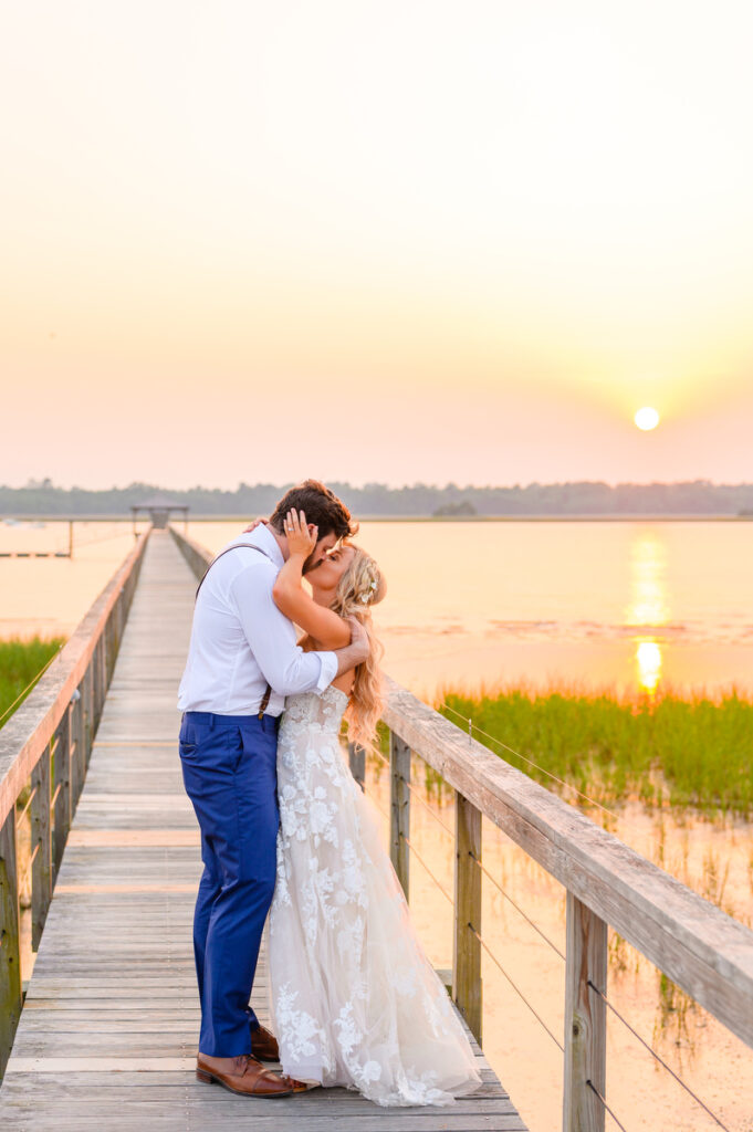 Lowndes Grove wedding bride and groom kiss on the dock at sunset