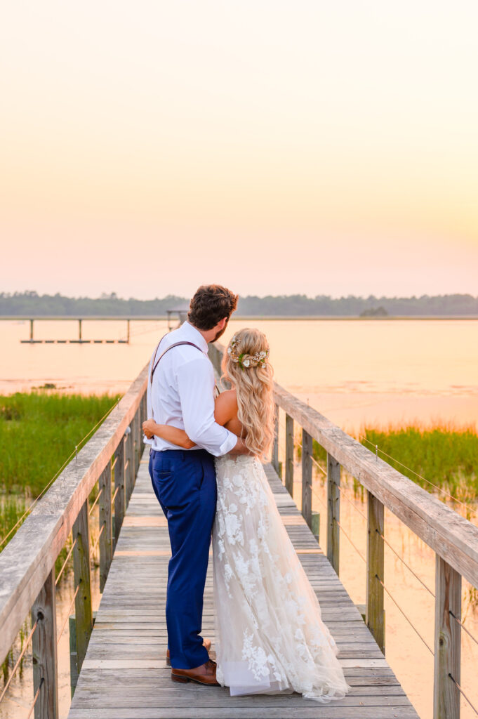 Lowndes Grove wedding couple holding each other on the dock at sunset