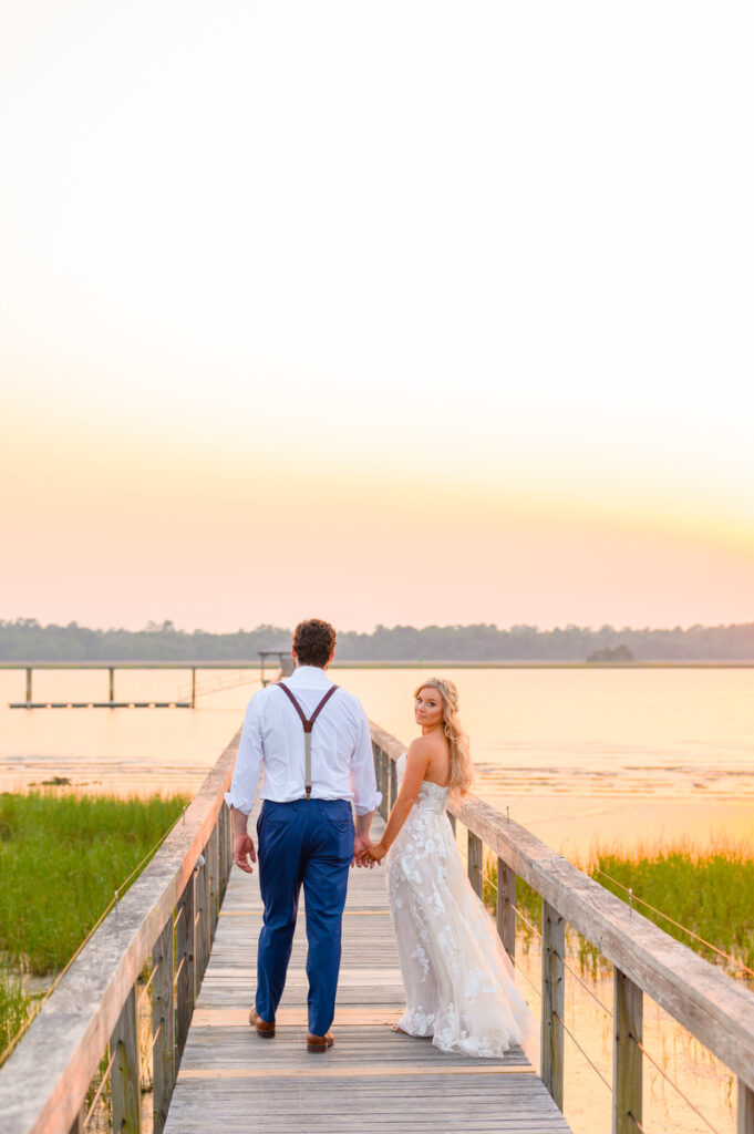 Lowndes Grove wedding bride and groom walking down the pier at sunset