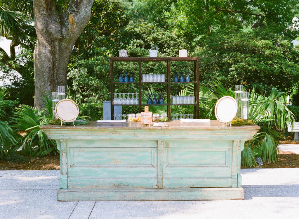 Lowndes Grove wedding reception bar with gold chargers and vintage green bar