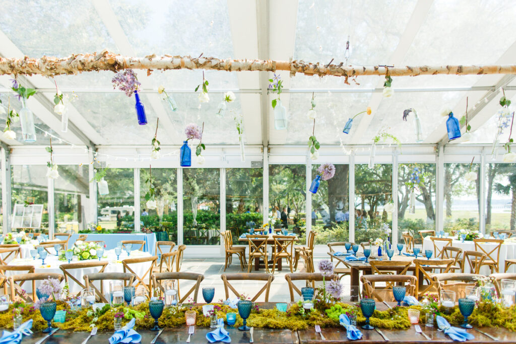 Lowndes Grove wedding reception wedding party table with blue goblets, green moss, and bespoke wood chandelier