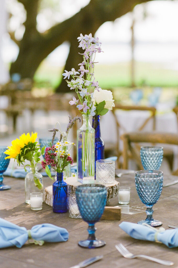 Lowndes Grove wedding reception decor with blue vintage bottles and blue goblets