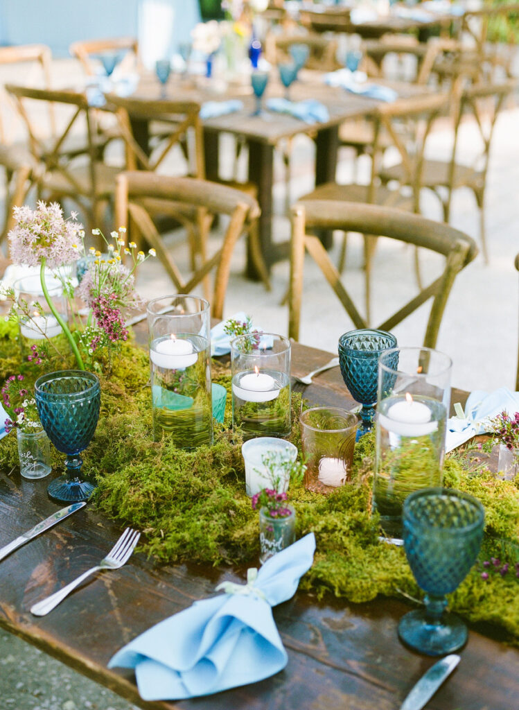 Lowndes Grove wedding reception table with green moss and blue vintage goblets