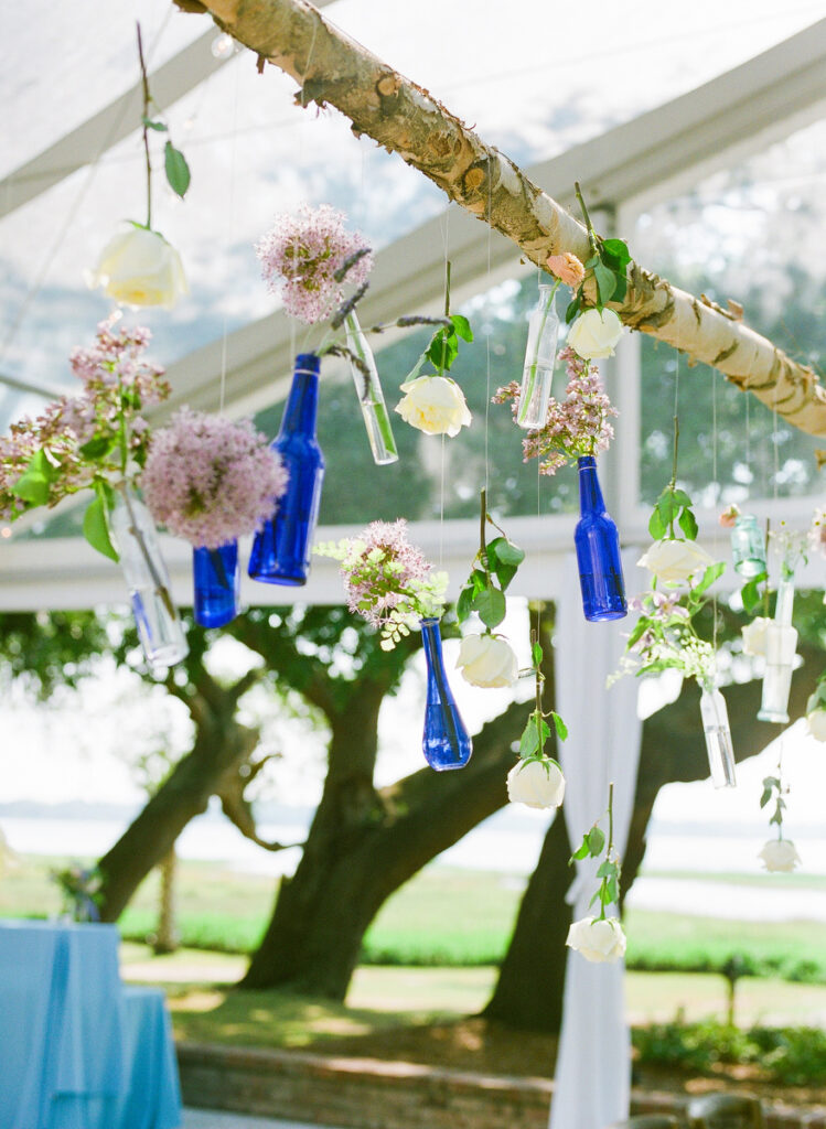 Lowndes Grove wedding bespoke chandelier of blue vases with white roses and purple flowers