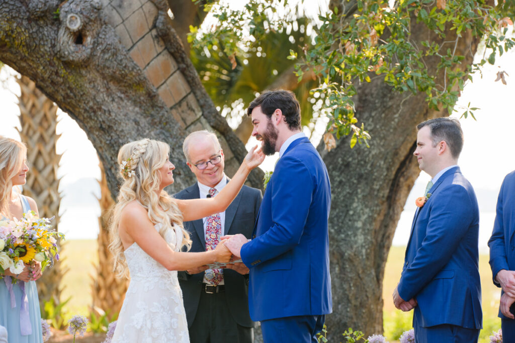 Lowndes Grove wedding bride touching groom's face during wedding ceremony