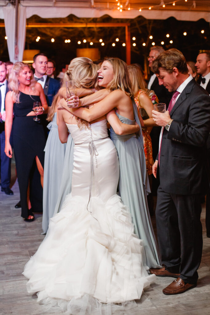 William Aiken House Wedding bridesmaids hugging bride during reception