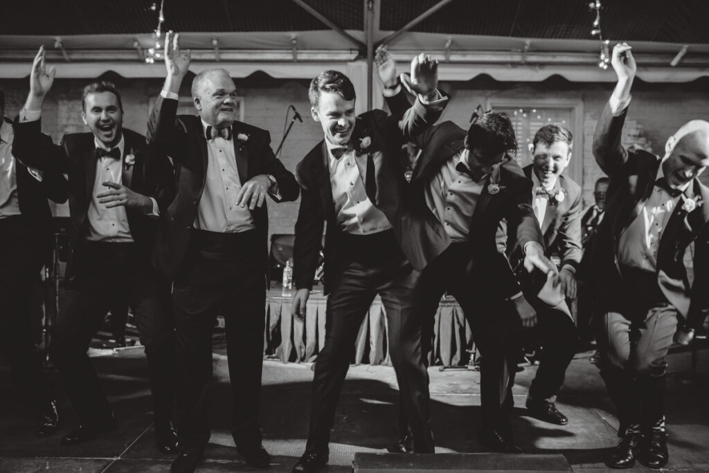 William Aiken House Wedding groom and groomsmen dancing on stage