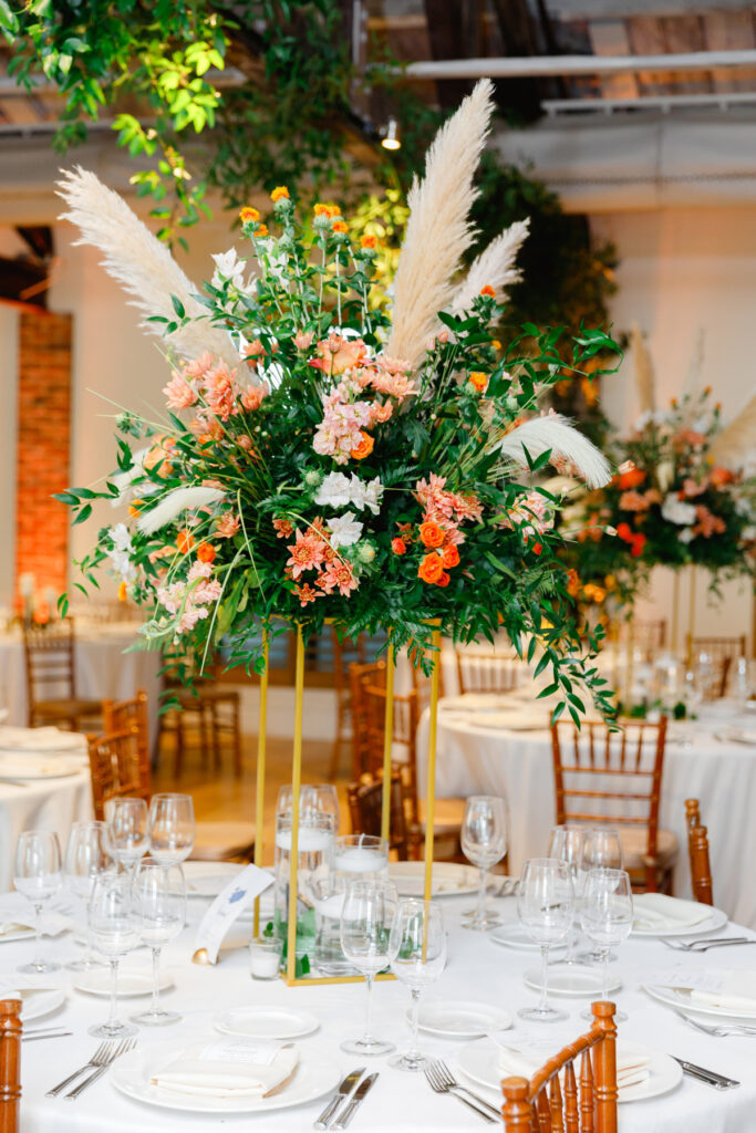 Tall floral centerpiece at a Cannon Green Wedding with orange and pink roses