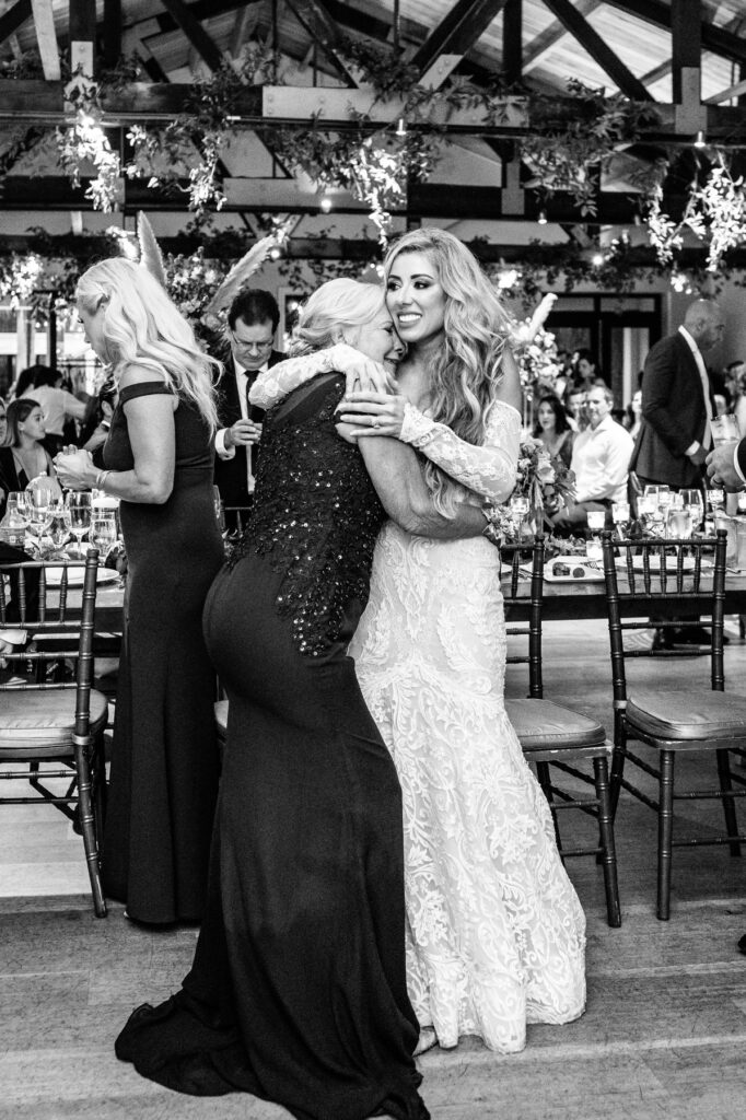 Bride hugs mother during reception in the Trolley Room at a Cannon Green Wedding