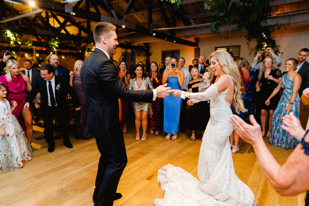 Bride and groom dance in the center of a circle surrounded by guests during the reception in the Trolley Room at a Cannon Green Wedding