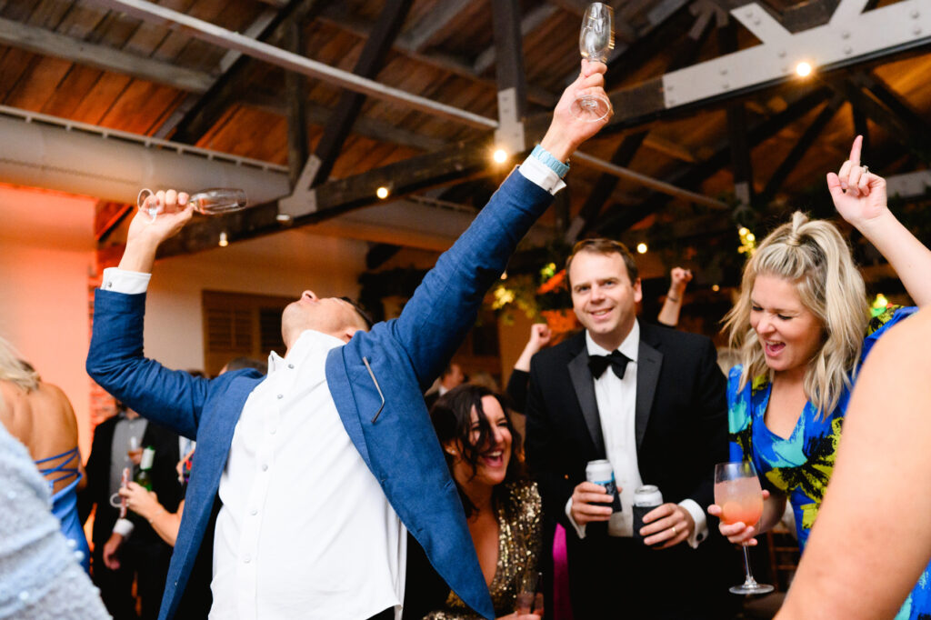 Guests on the dance floor dancing to "Shout" during the reception in the Trolley Room at a Cannon Green Wedding