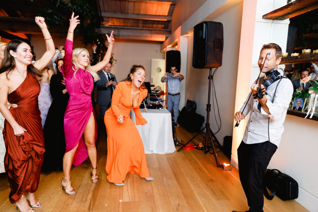 Guests excited about electronic violin player during the reception in the Trolley Room at a Cannon Green Wedding