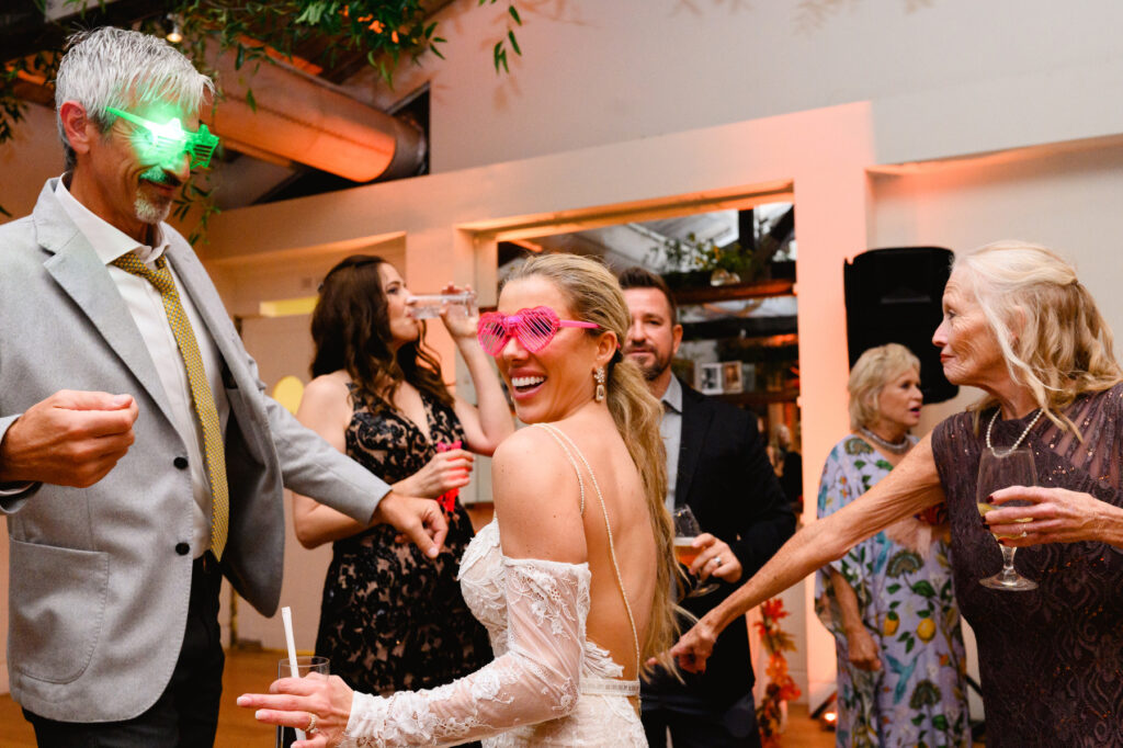 Bride with glow in the dark pink heart glasses during the reception in the Trolley Room at a Cannon Green Wedding