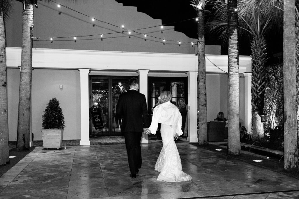 Bride and groom walking in the courtyard at a night at a Cannon Green Wedding