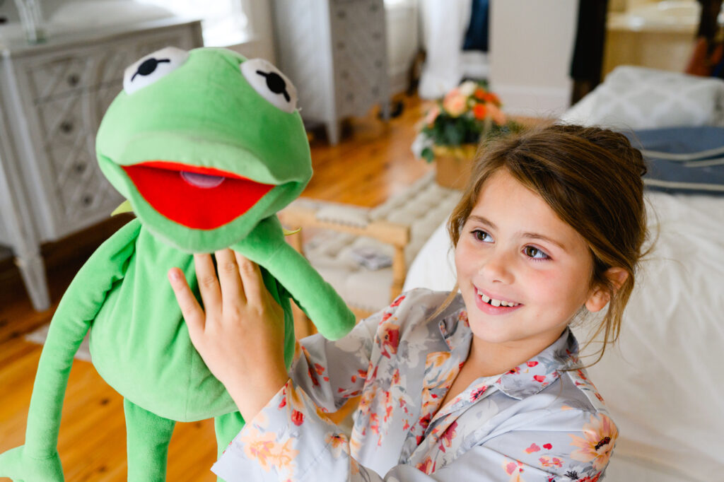 Kermit the frog stuffed animal being held by a girl