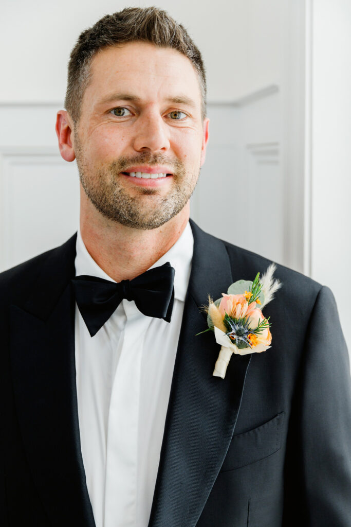 Portrait of groom in black tux and black bow tie