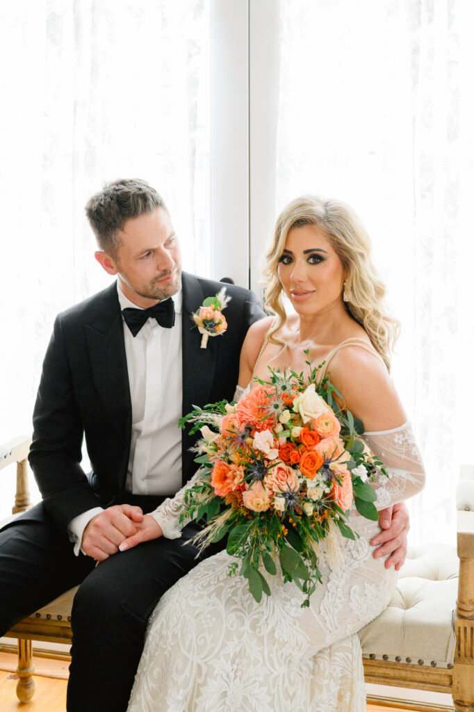 Portrait of groom looking at bride while sitting on an upholstered bench