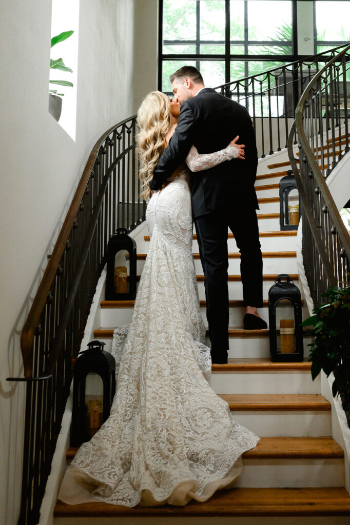 Bride and groom kissing on stairs at Cannon Green restaurant