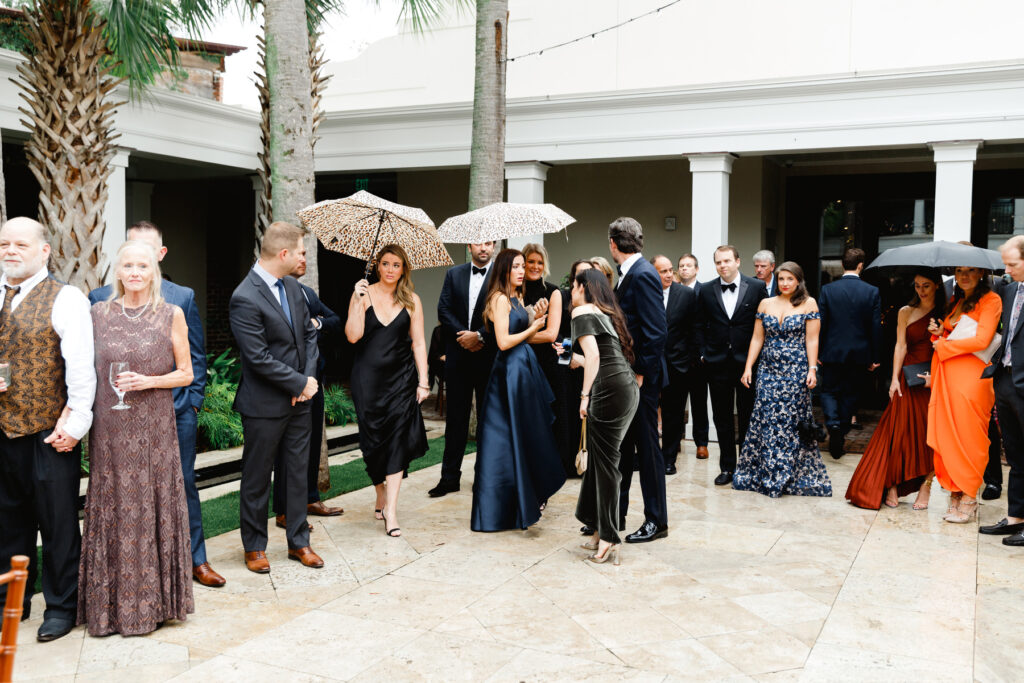 Wedding guests gather in the courtyard for a rainy Cannon Green wedding