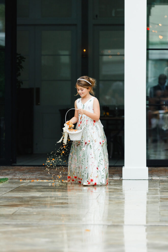 Flower girl dropping flower petals during processional at a Cannon Green wedding