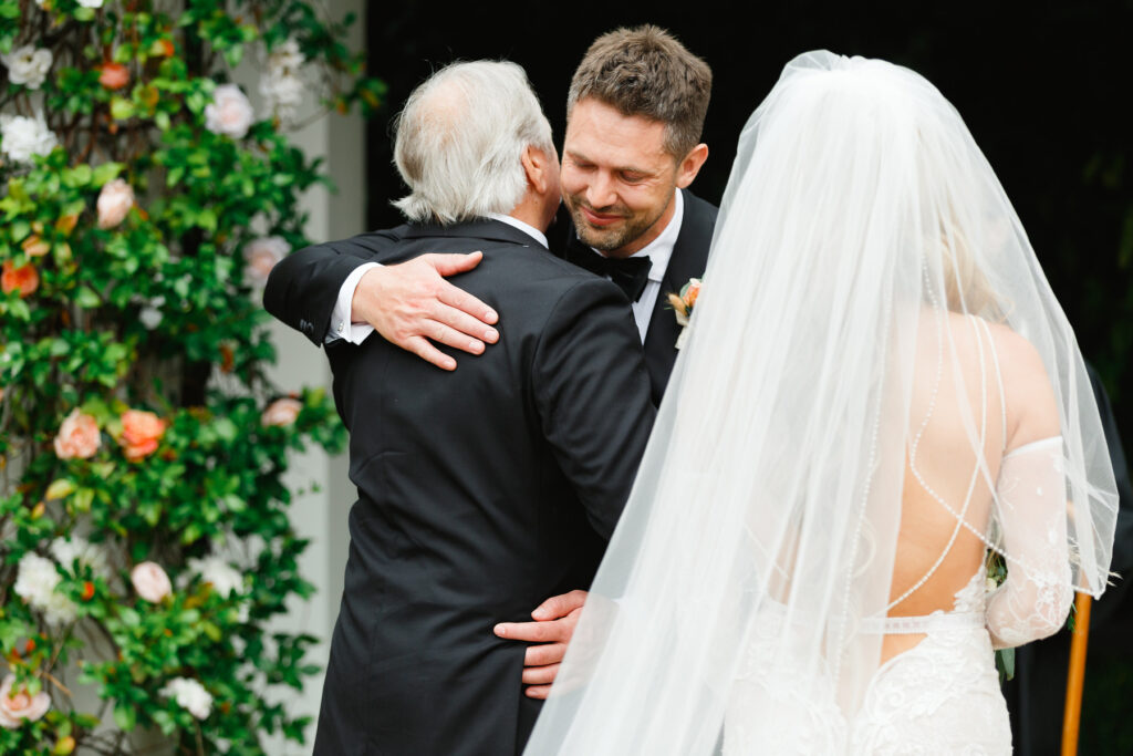 Groom hugs father of the bride at a Cannon Green Wedding