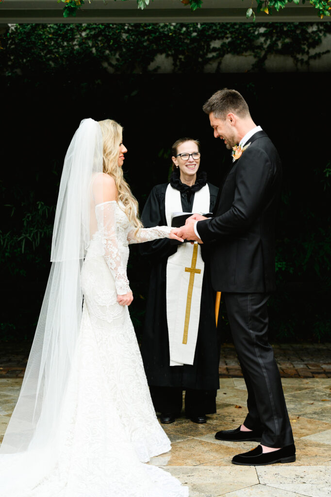 Groom slipping ring onto bride's finger during the ceremony at a Cannon Green Wedding