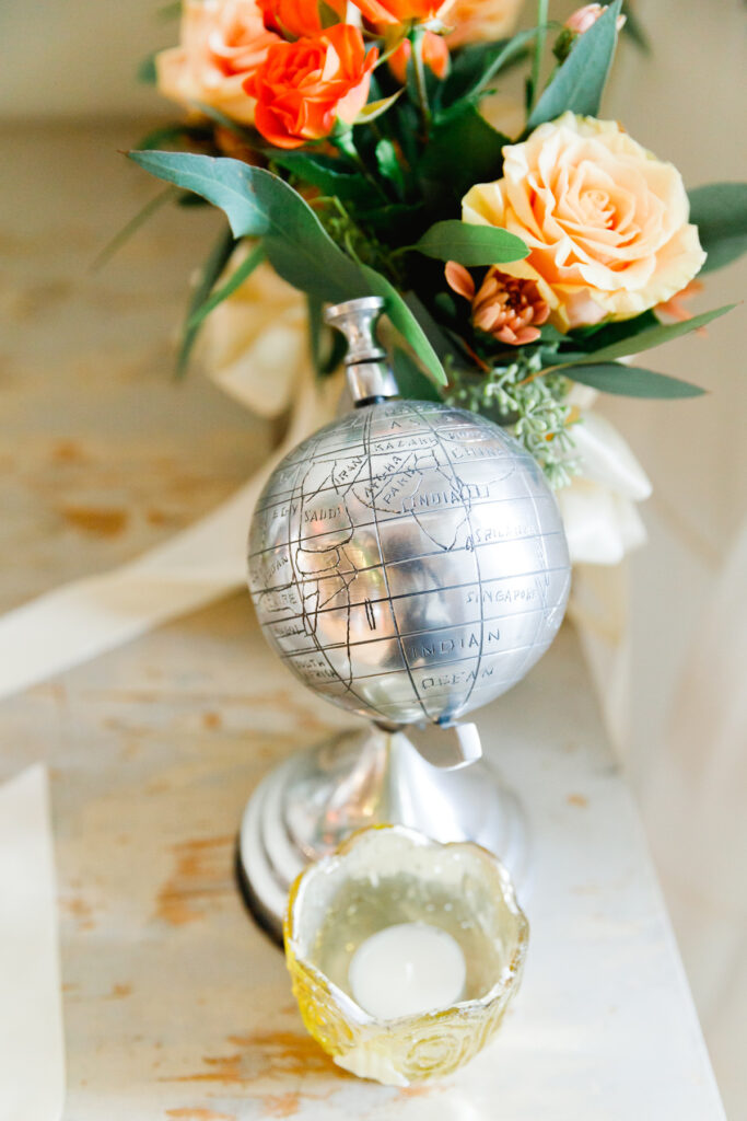 A silver mini globe and gold candle holder at a Cannon Green Wedding