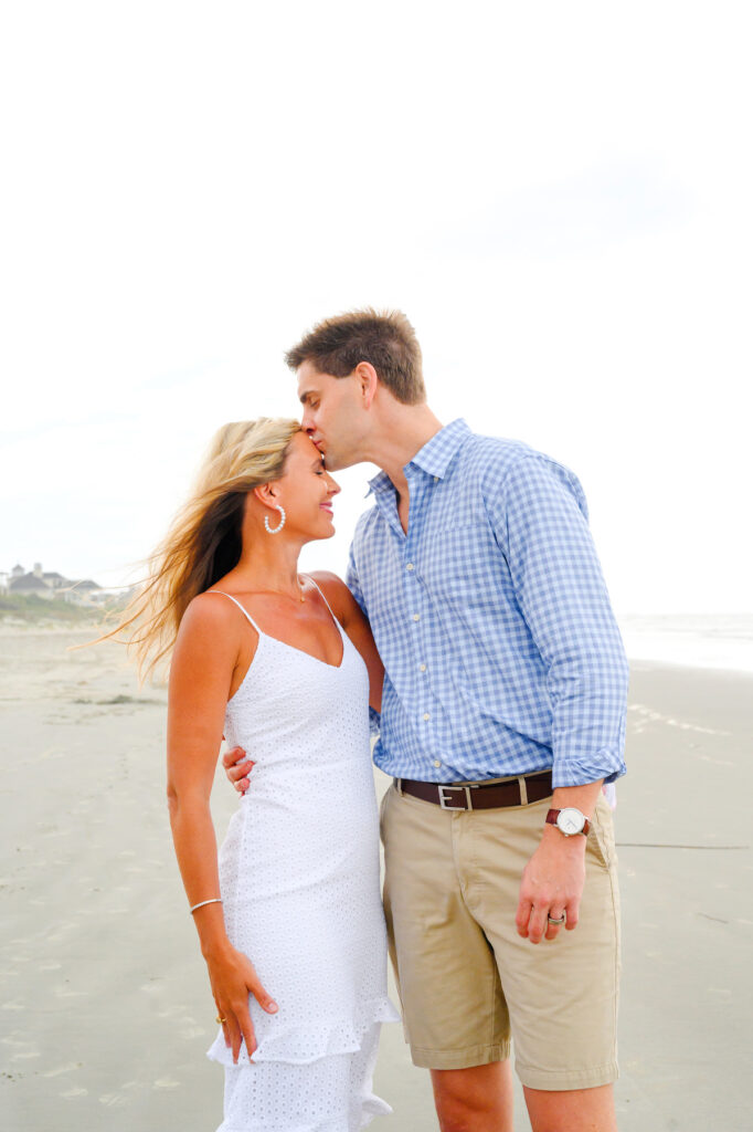 Husband kisses wife's forehead during a Kiawah beach family photo