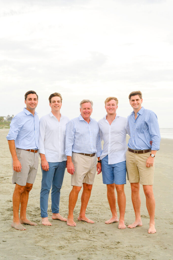 Father poses with his son and son-and-laws during a Kiawah beach family photo