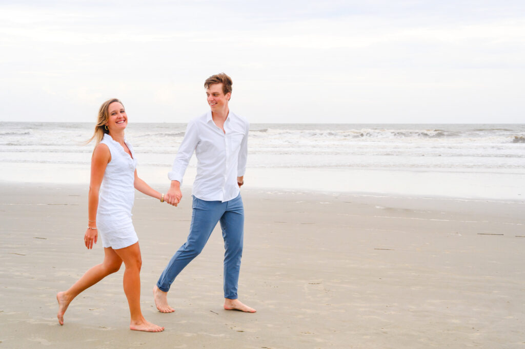 Newlywed couple walk along the beach during a Kiawah beach family photo