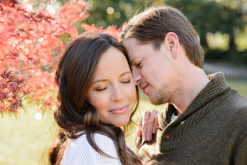 Woman being nuzzled by a man during their fall Charleston engagement session