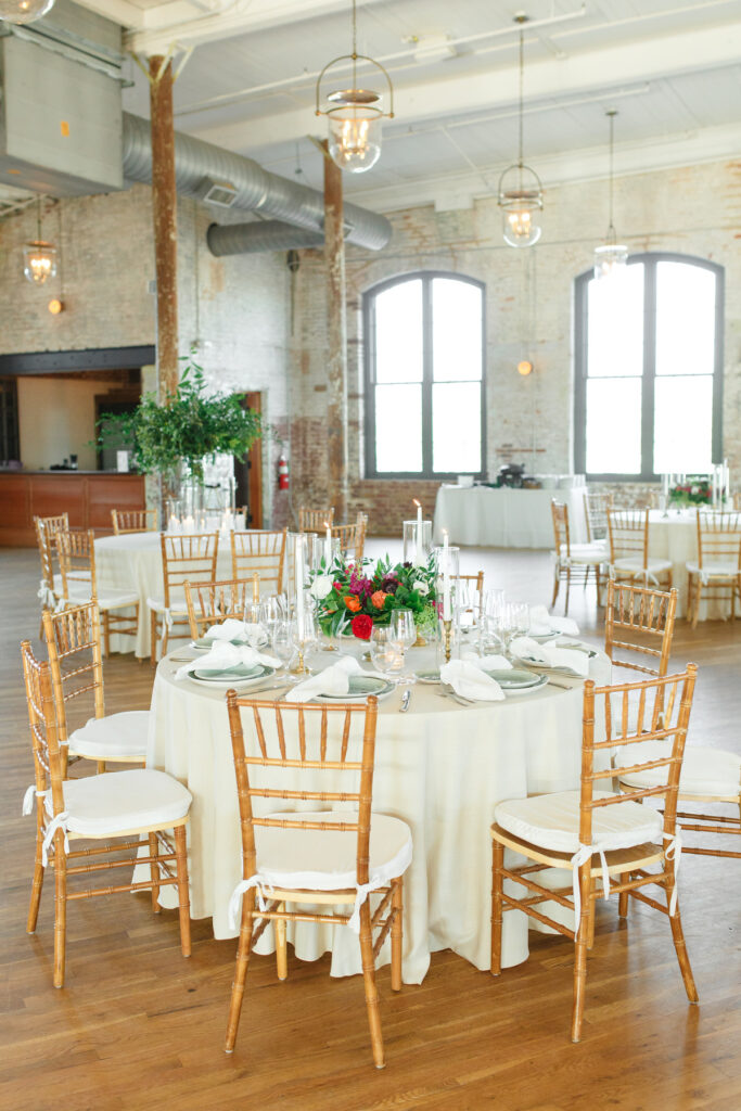 Cedar Room wedding reception floral centerpiece with anemone flower and pink roses with green plates place settings