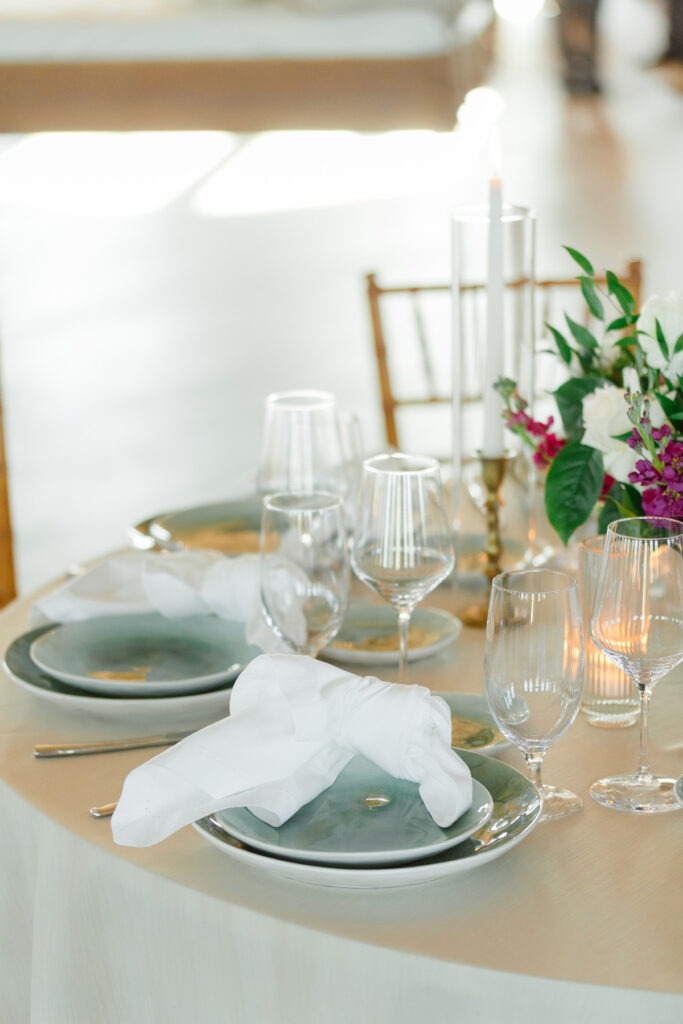 Cedar Room wedding reception floral centerpiece with anemone flower and pink roses with green place place setting