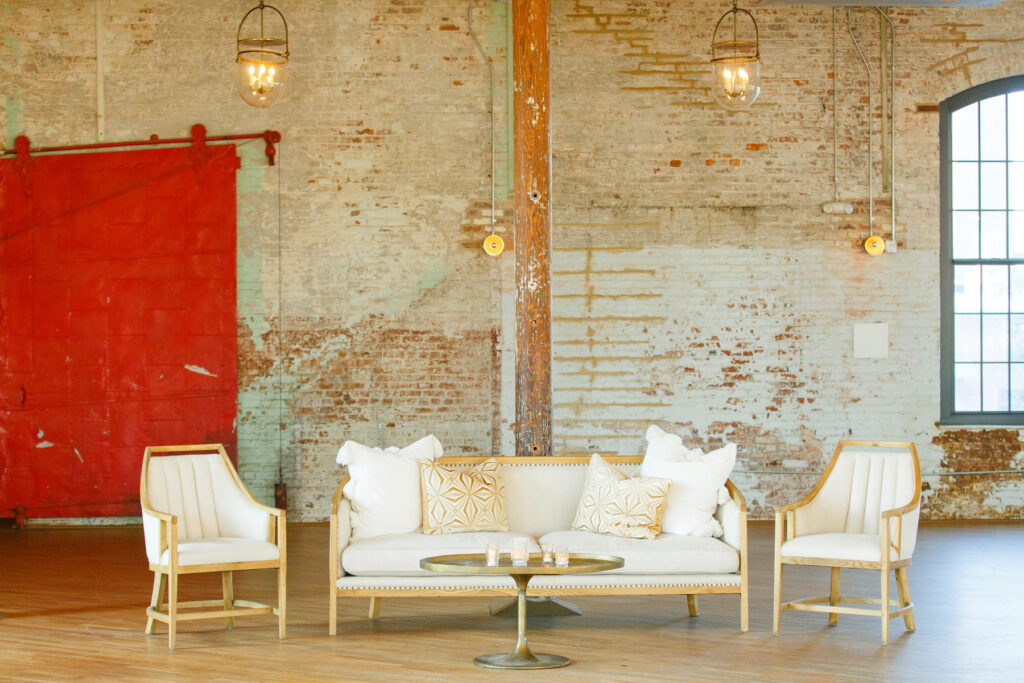 Cedar Room wedding reception with white and beige lounge set of a sofa and two chairs with pillows