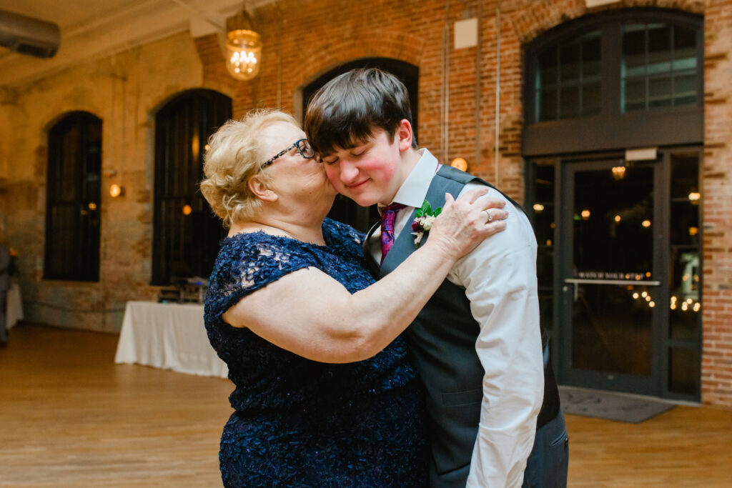 Cedar Room wedding with the mother of the bride kissing her grandson on the cheek