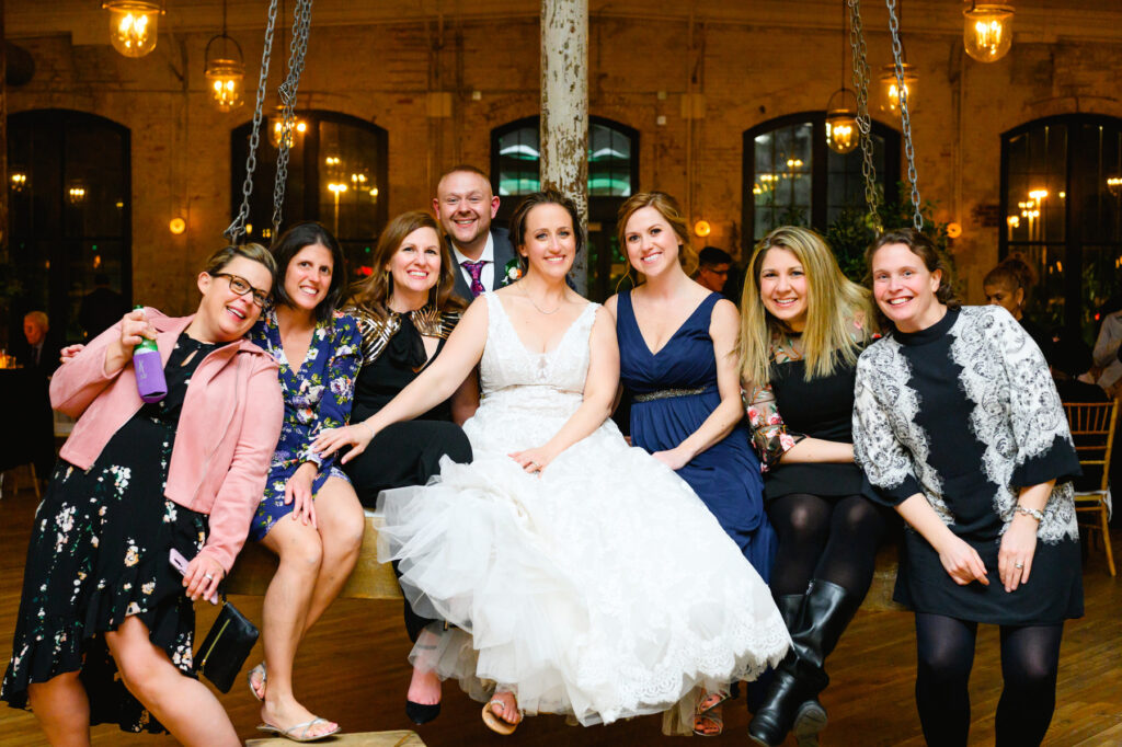 Cedar Room wedding with the bride on a swing at the reception posing for a photo with her friends