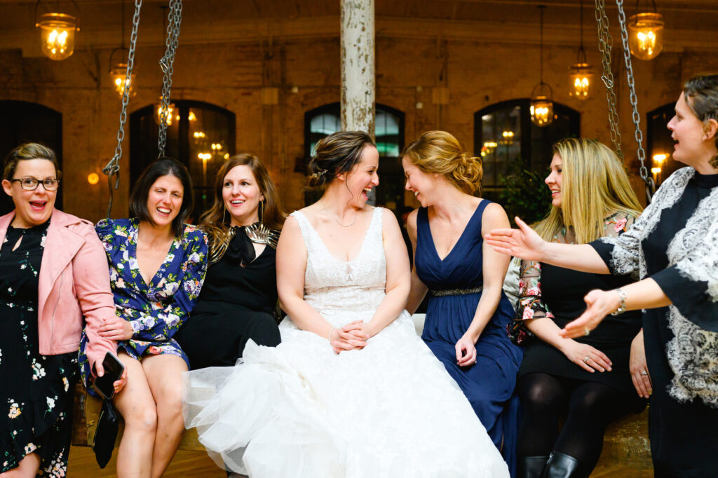 Cedar Room wedding with the bride on a swing at the reception laughing with her friends