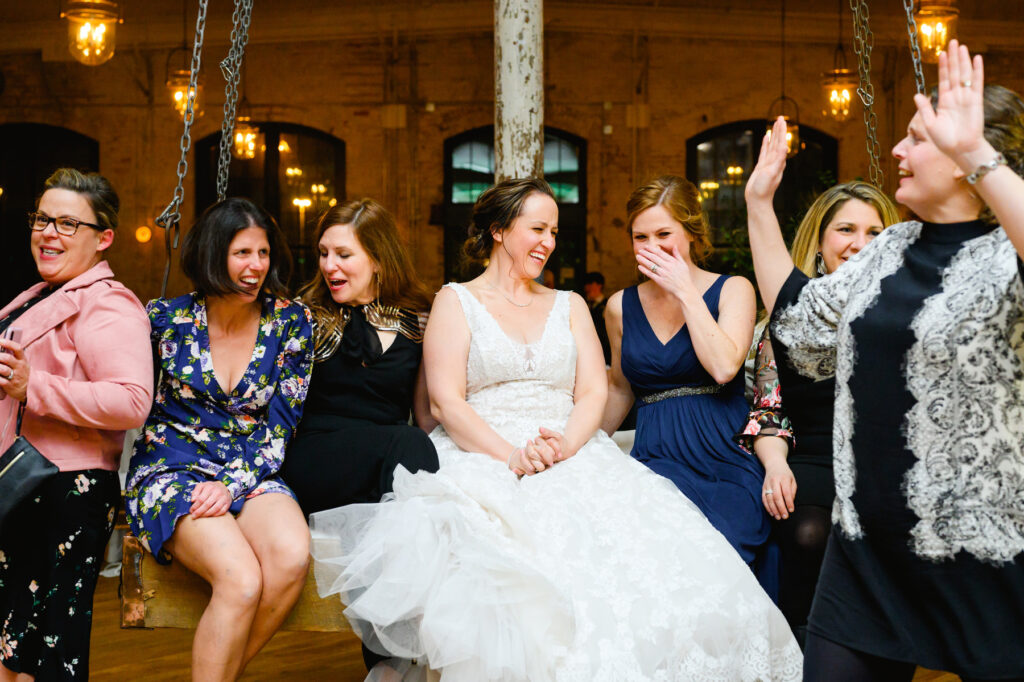 Cedar Room wedding with the bride on a swing at the reception laughing with her friends