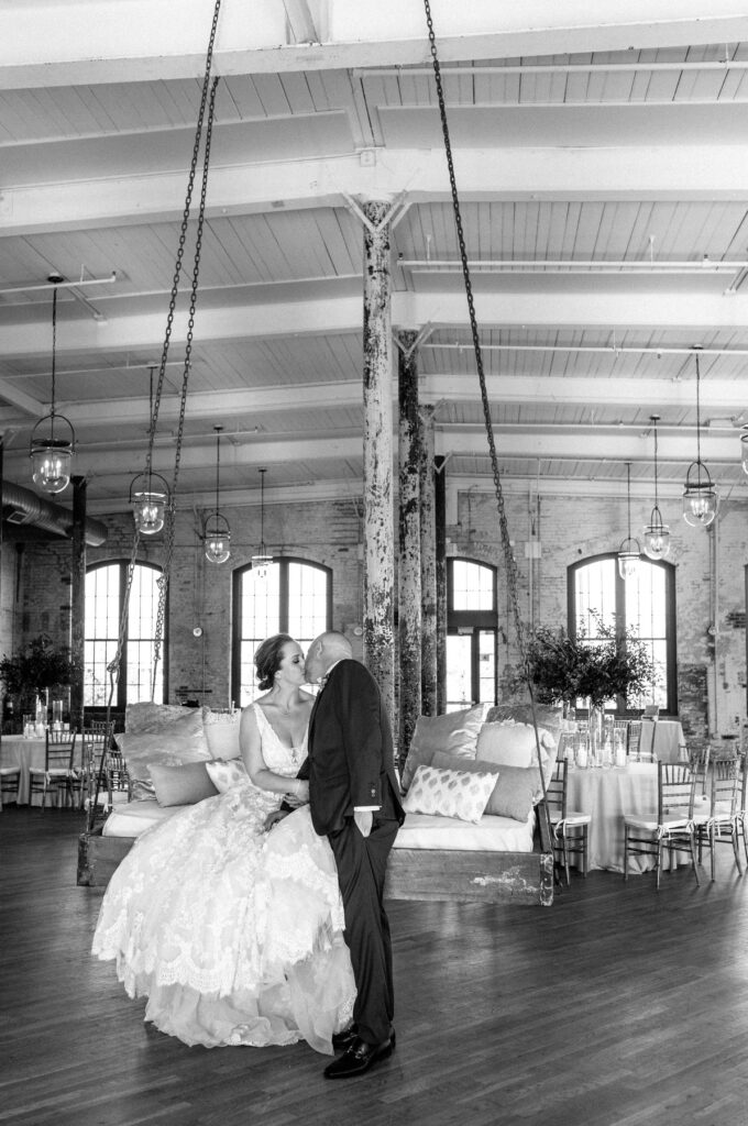 Cedar Room wedding portrait of bride and groom kissing on the swing in black and white