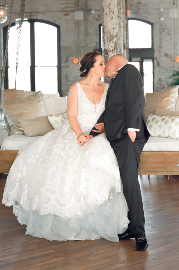 Cedar Room wedding portrait of bride and groom kissing on the swing