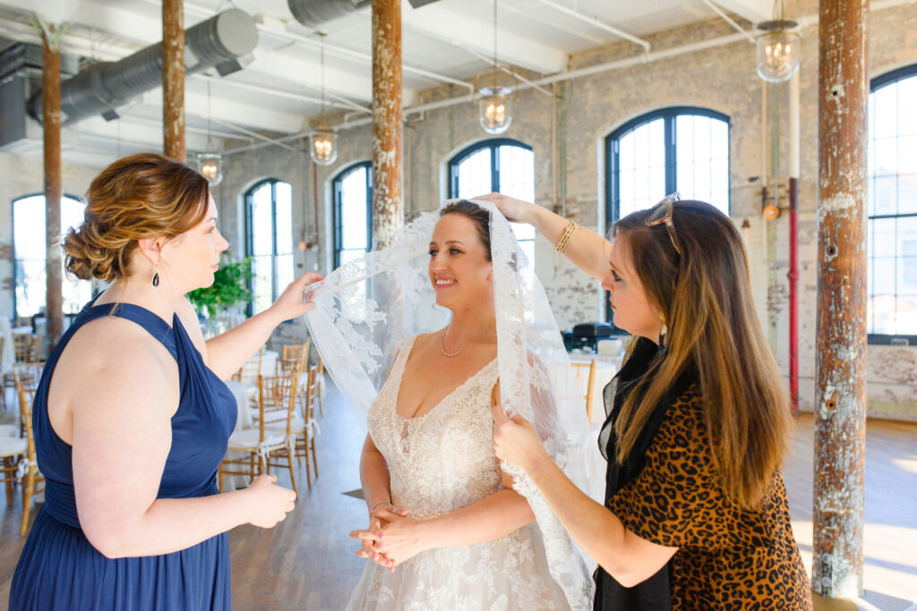 Cedar Room wedding candid of the bride having veil put on