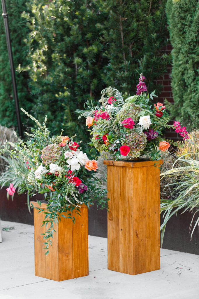 Cedar Room wedding ceremony altar flowers with pink, red, orange, and white roses