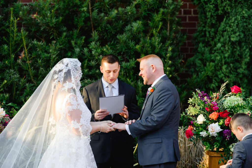 Cedar Room wedding of bride and groom doing the wedding ring exchange at the ceremony