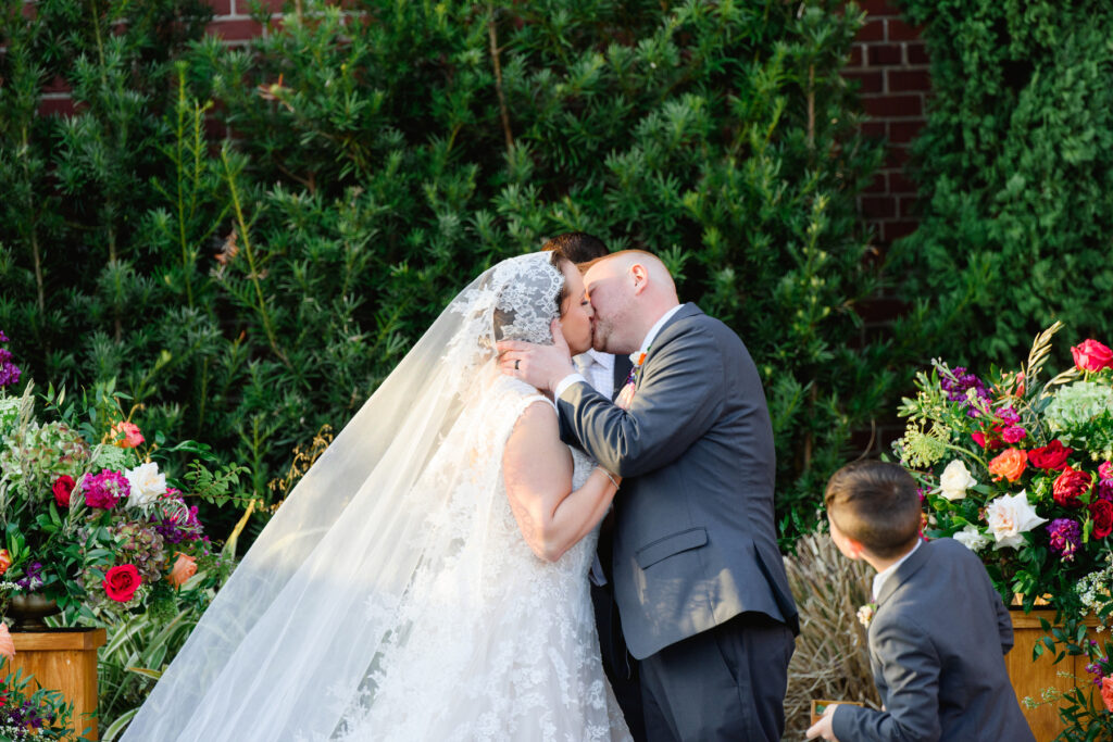 Cedar Room wedding of bride and groom kissing at the ceremony