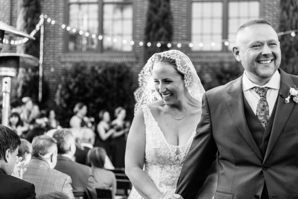 Cedar Room wedding of bride and groom walking up the aisle in black and white