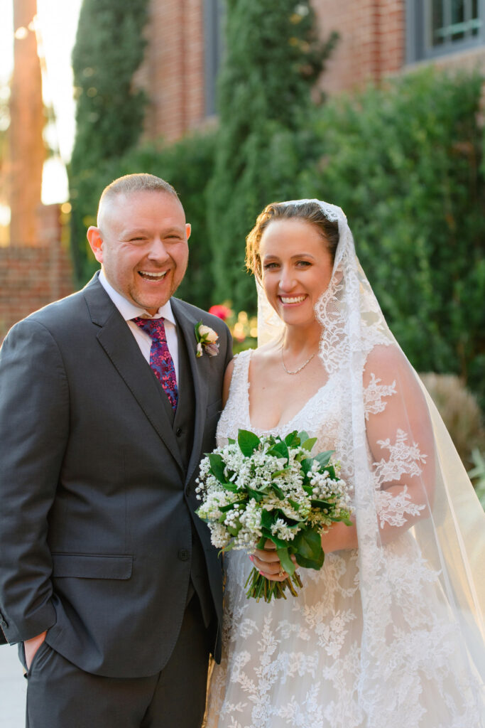 Cedar Room wedding of bride and groom posing for portrait in the courtyard looking at the camera