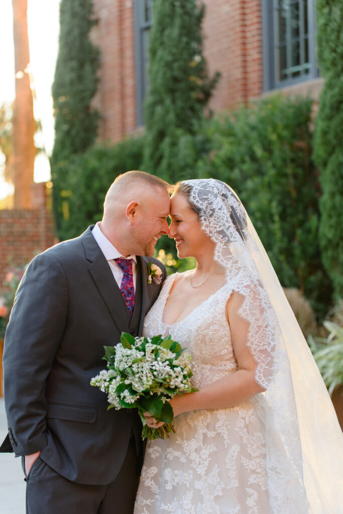 Cedar Room wedding of bride and groom nuzzling foreheeads in the courtyard