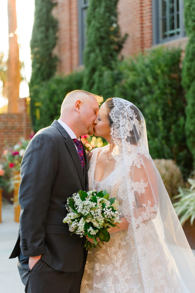 Cedar Room wedding of bride and groom kissing in the courtyard